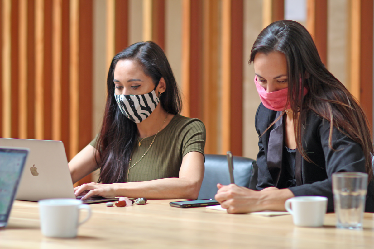 Two people wearing facemasks working in coworking space - Credit to @toolboxla, image supplied via Unsplash