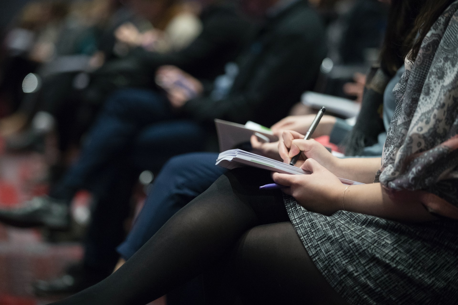 Note taking at a conference. Photo by @climatereality via Unsplash